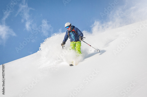 Mężczyzna narciarz freeride w górach poza trasą