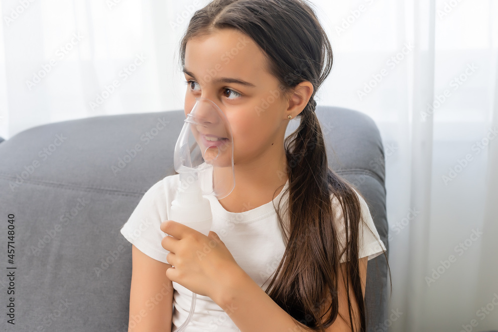 Little girl making inhalation with nebulizer at home. child asthma inhaler inhalation nebulizer steam sick cough concept. Little girl making inhalation with nebulizer at home. child asthma inhaler inhalation nebulizer steam sick cough concept.