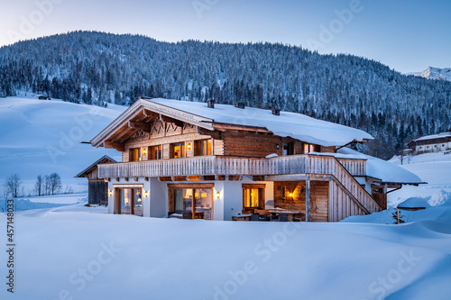 Canvas Print Wooden chalet in the alps on a cold winter evening