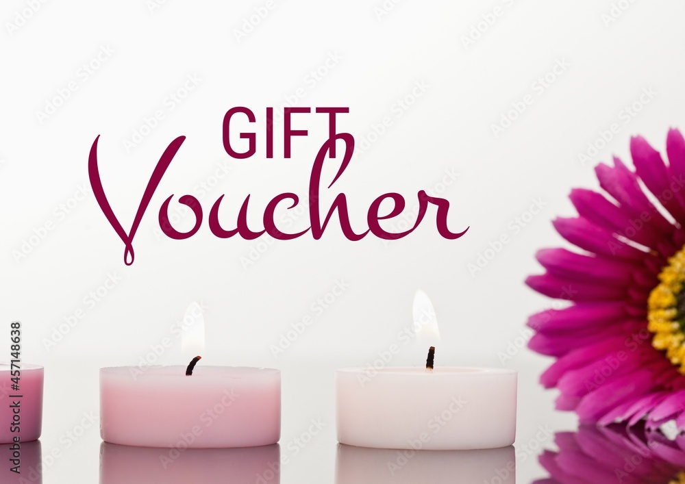 Gift voucher text against burning candles and flower Gift voucher text against burning candles and flower