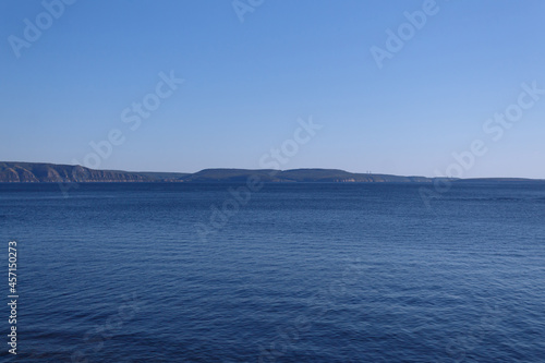 Autumn view of the wide Volga River in the heartland of Russia. Blue sky, wooded mountains on the opposite shore.