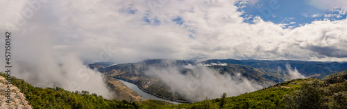Wide panorama of the Douro River and its valleys, Port wine production region, low clouds cover the mountains
