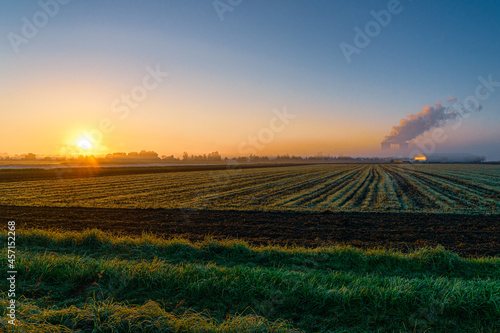 Sonnenaufgang am Atomkraftwerk Gundremmingen  Blick auf Felder  K  hlt  rme und Dampfwolke im Morgenlicht