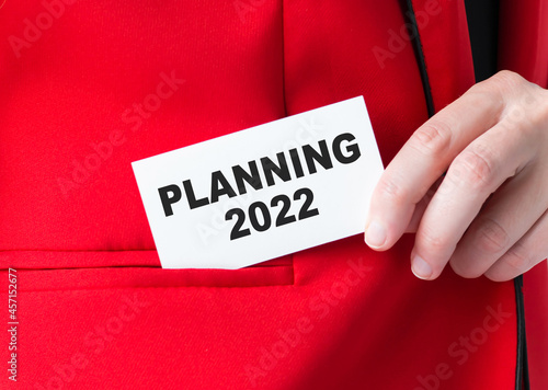 Businessman holding a card with text GOALS 2022. Aims for the upcoming year.Business concept.