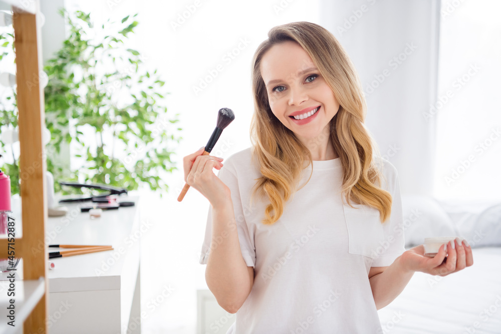 Photo portrait young woman in white outfit doing make up keeping powder brush Photo portrait young woman in white outfit doing make up keeping powder brush