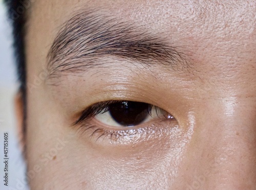 Asian, Chinese young man with single eyelid or monolid. A monolid means that there is no visible crease line below the brow area. photo