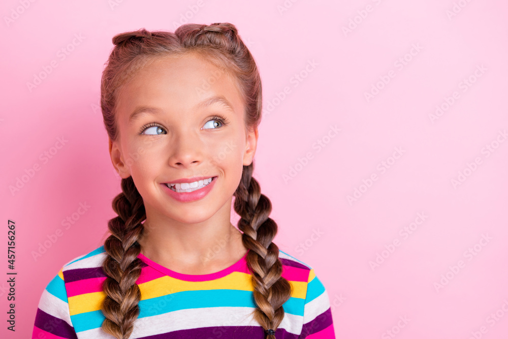 Photo of cheerful interested little lady look empty space toothy smile wear striped shirt isolated pink color background