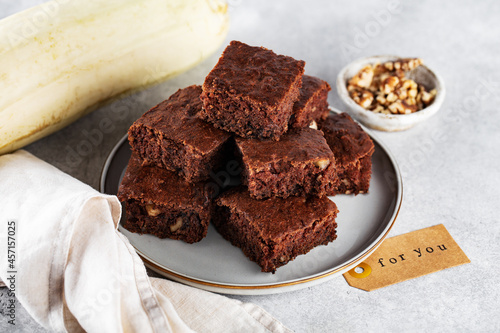 zucchini brownies with walnuts, on a plate, napkin, horizontally