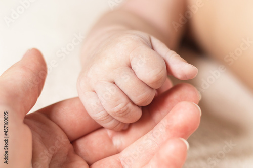 Hand of newborn baby and mother. New generation. Parenting, family and childcare concept.