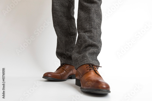 close up of Brown leather with man leg in black pants on white background.