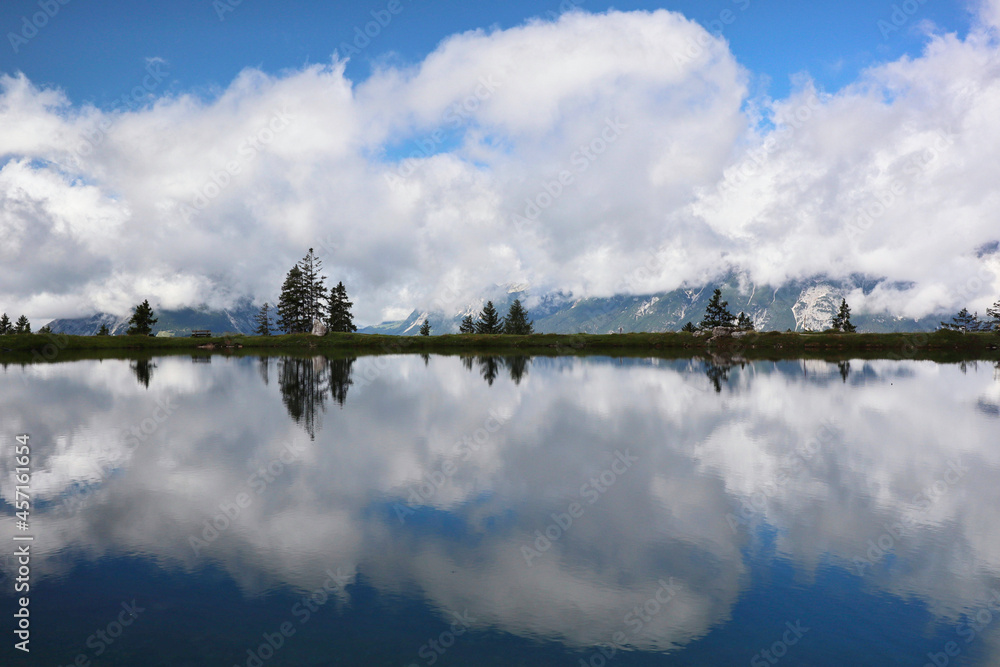 Lake Reflection of Tree, Alps and Sky with Cloud in Tyrol. Scenic View of Water called Kaltwassersee in Austria.