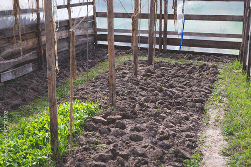 Small do-it-yourself greenhouse. Land prepared for planting.