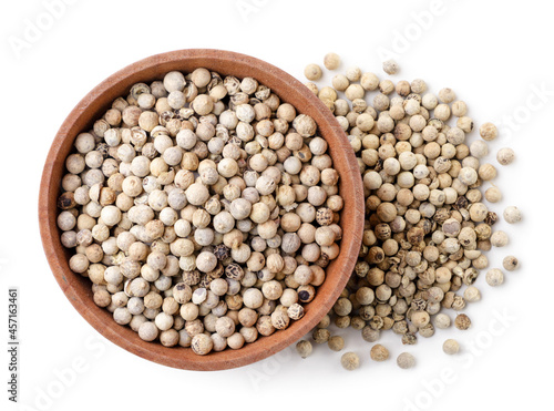 Dry white peppercorns in a plate on a white background, isolated. Top view