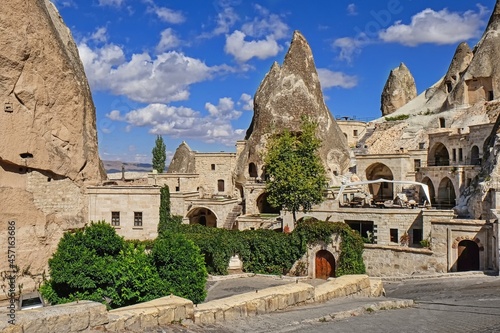 Travel to fairy Cappadocia. Street with restaurants and cave hotels carved inside stone rock at sunny day in old town Goreme. Cappadocia, Nevsehir Province, Central Anatolia, Turkey