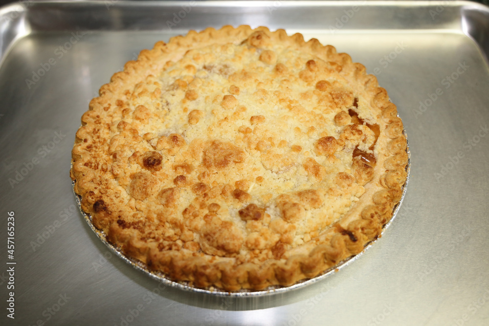 A freshly baked Dutch apple pie on a cookie sheet.