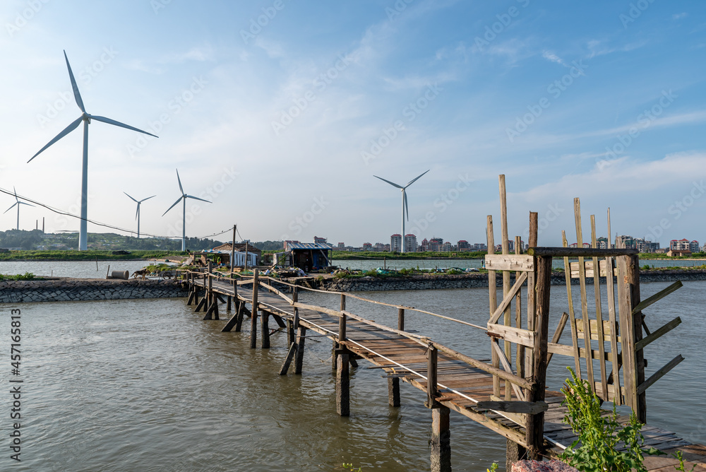 Fototapeta premium Coastline wind turbine under blue sky