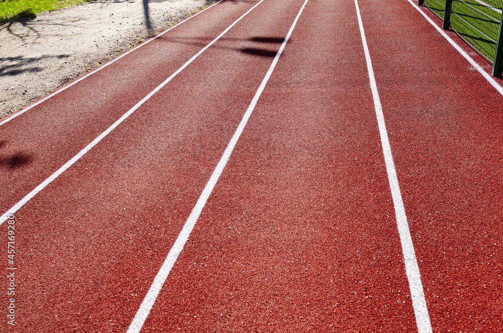 Fototapeta premium Red treadmill on sport field. Running track on the stadium