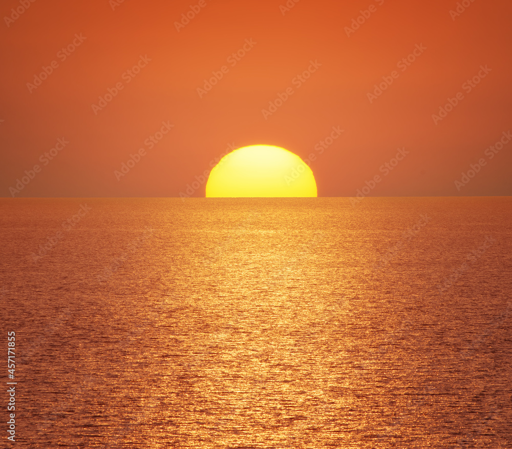 Big sun and sea sunset background.