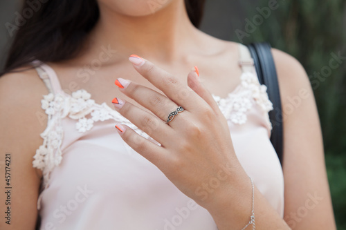 Woman wearing luxury ring standing on the street. Fashion concept.