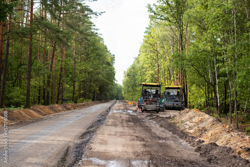 Constructing new asphalt roads. Modern road repairing equipment near new constructed line of high quality asphalt