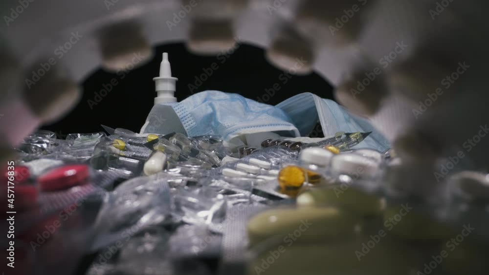 CU, macro: numerous different colorful antibacterial drugs near mask as disease treatment accessories on black background zoom in extreme close view CU, macro: numerous different colorful antibacterial drugs near mask as disease treatment accessories on black background zoom in extreme close view