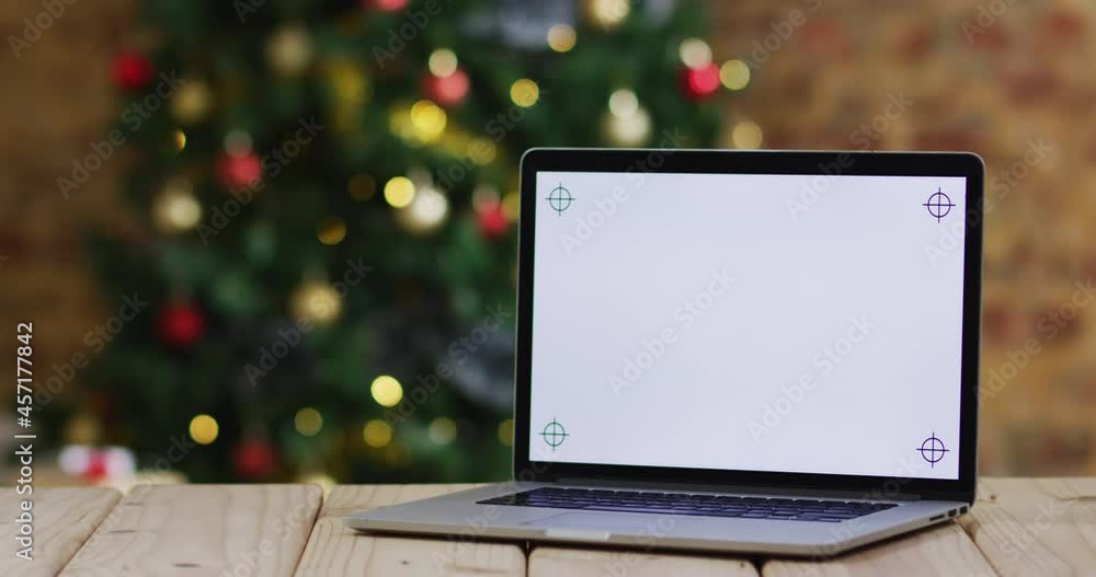Video of wooden table with laptop over christmas tree Video of wooden table with laptop over christmas tree