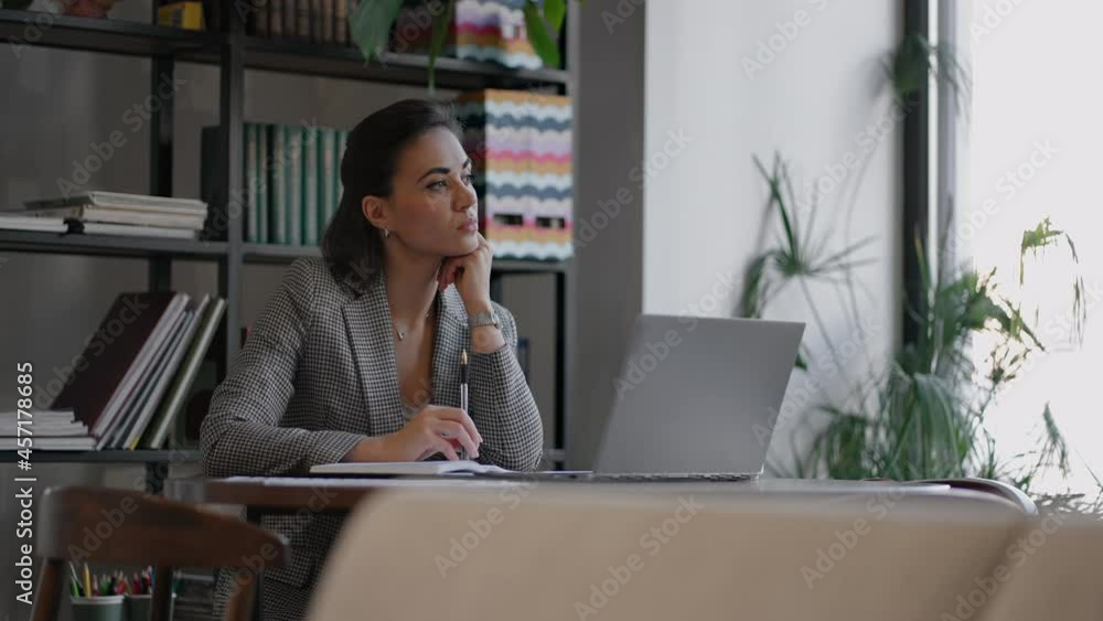 Arabian Hispanic woman working financial paperwork seated at workplace using laptop looks concentrated while makes task, prepare, check report having fruitful workday. Student learning process concept Arabian Hispanic woman working financial paperwork seated at workplace using laptop looks concentrated while makes task, prepare, check report having fruitful workday. Student learning process concept