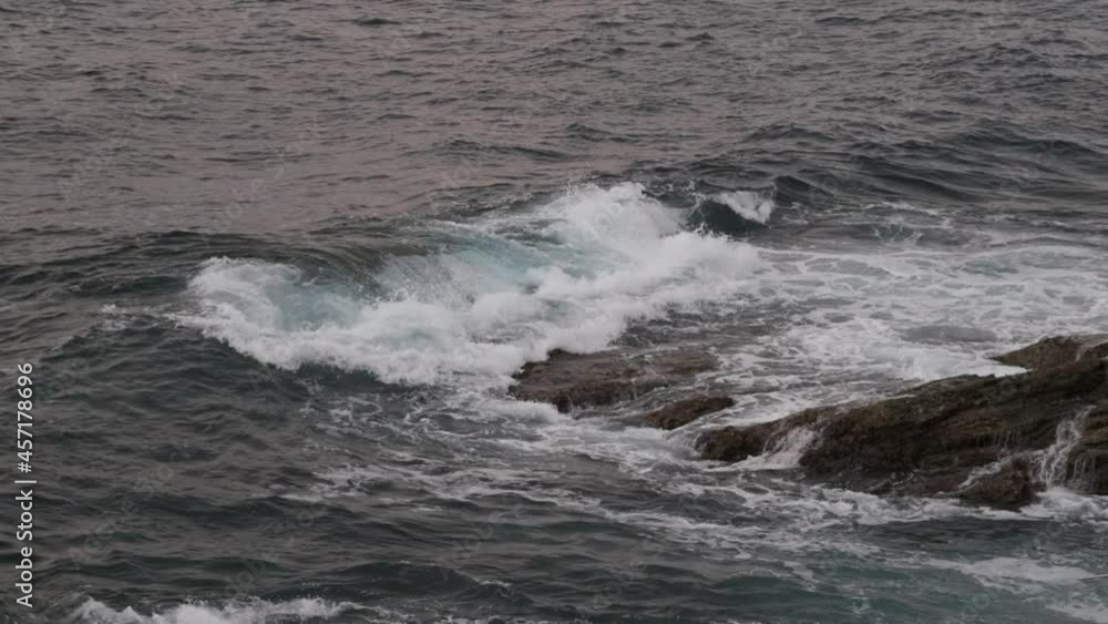 Slow motion of the sea waves crashing against the rocks of the coastline Slow motion of the sea waves crashing against the rocks of the coastline