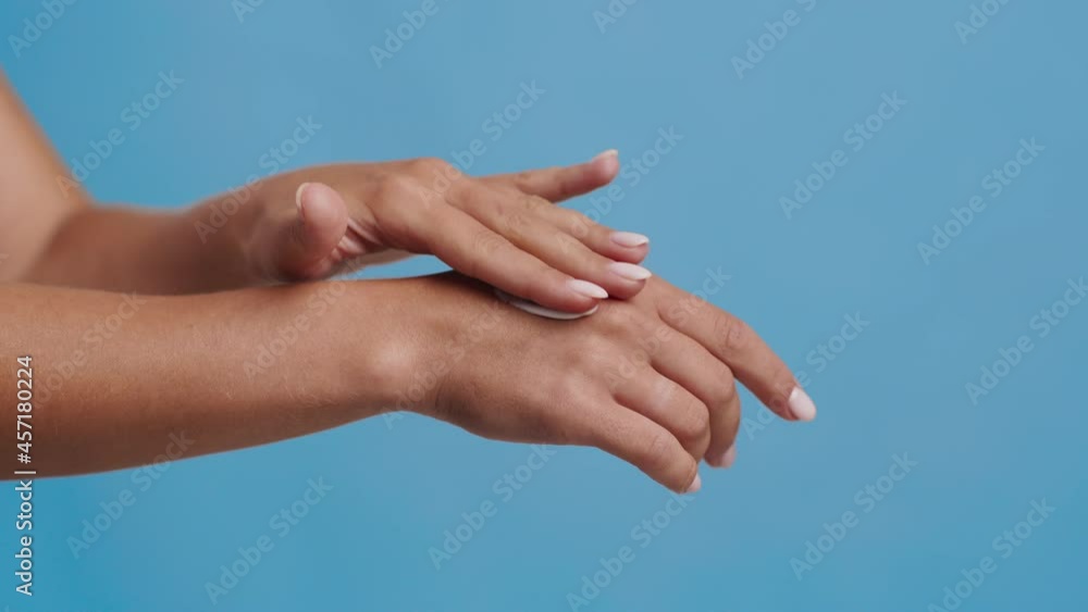 Unrecognizable Lady Applying Cream Moisturizer On Hands, Blue Background, Closeup Unrecognizable Lady Applying Cream Moisturizer On Hands, Blue Background, Closeup