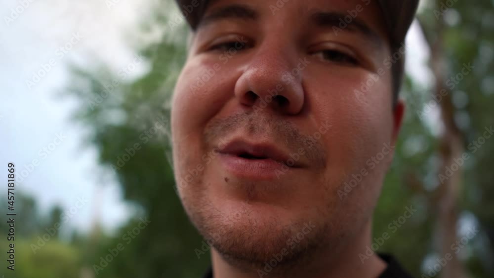 man smokes a cigarette close-up while standing on the street. 4k footage man smokes a cigarette close-up while standing on the street. 4k footage