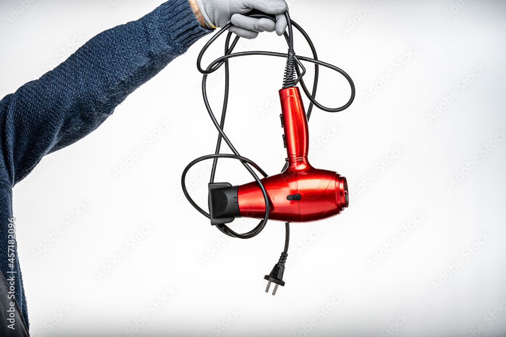 a red hair dryer in men's hands