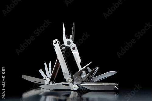 Konstfotografi Folding multitools on a dark back. Metal pocket multi-tools.