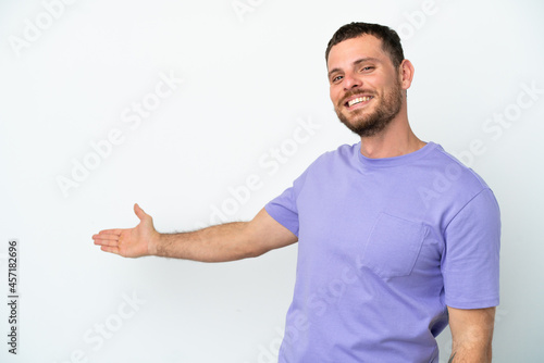 Young Brazilian man isolated on white background extending hands to the side for inviting to come