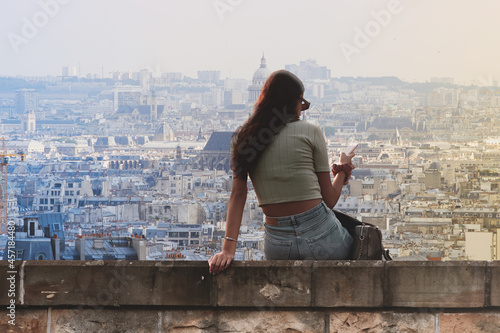Piękna młoda kobieta przegląda smarfona w Paryżu