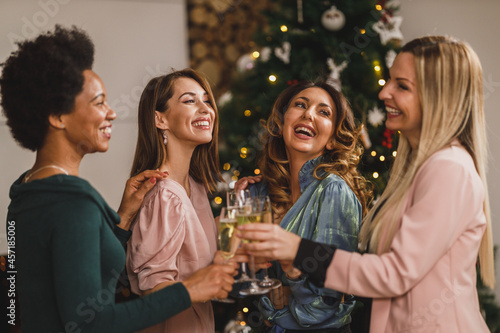 Four Multiracial Female Friends Having Fun And Make Toast As They Celebrate At Home Christmas Party