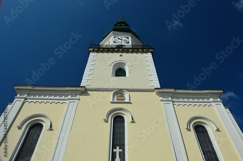 Front view of tower and windows of Church of Saint Stephen The King in Modra, western Slovakia, build in renaissance and classicistic historicist style. Summer blue skies in background.