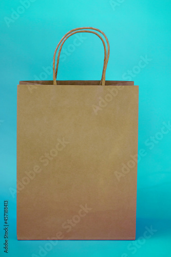 Eco gift bag with copy space on colored background. Vertical photo