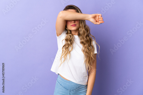 Young Brazilian woman isolated on purple background covering eyes by hands © luismolinero