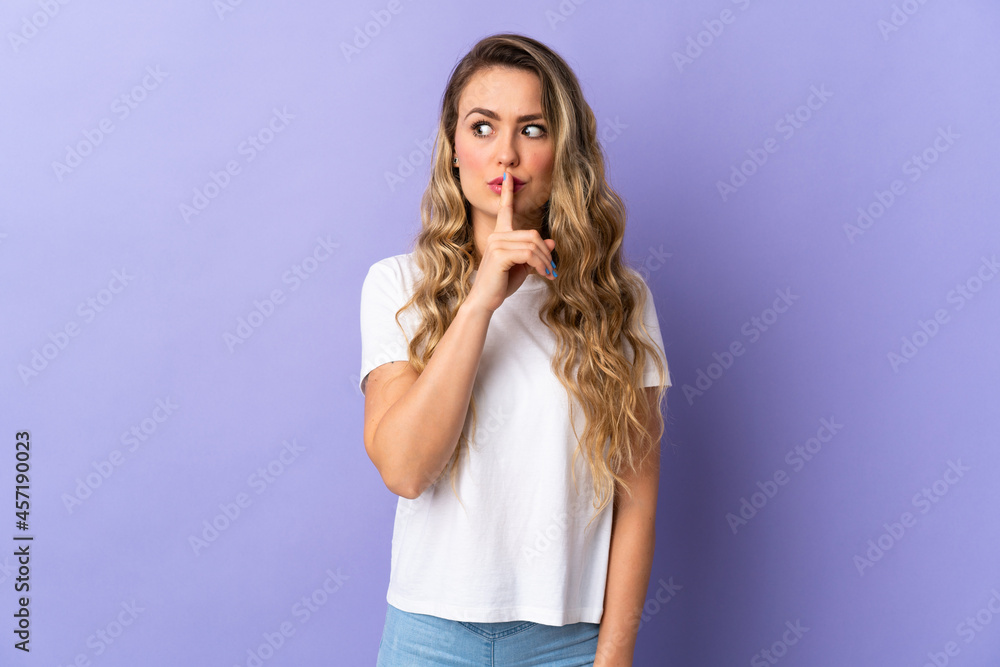 Fototapeta premium Young Brazilian woman isolated on purple background showing a sign of silence gesture putting finger in mouth