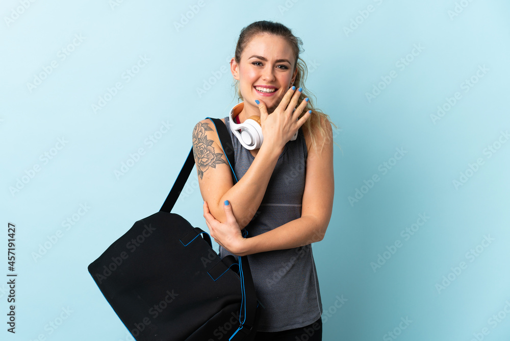 Young sport Brazilian woman with sport bag isolated on blue background happy and smiling Young sport Brazilian woman with sport bag isolated on blue background happy and smiling