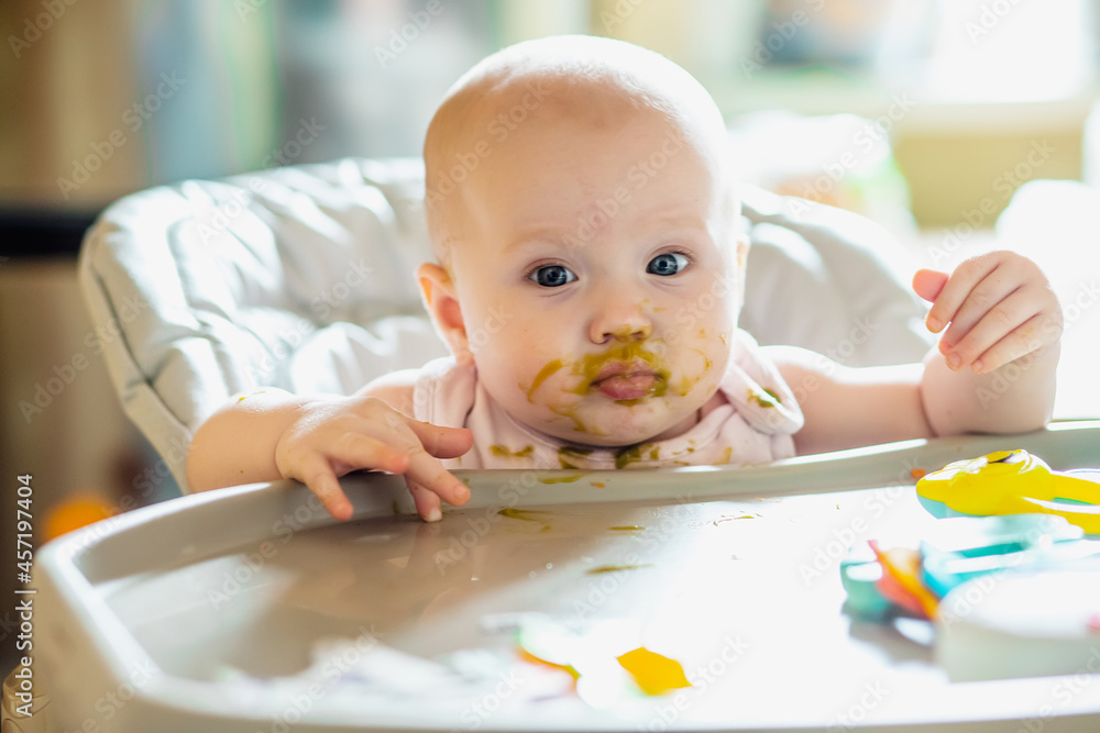 little girl with smeared face in broccoli puree. first lure of child. Healthy food for children up to year. little girl with smeared face in broccoli puree. first lure of child. Healthy food for children up to year.