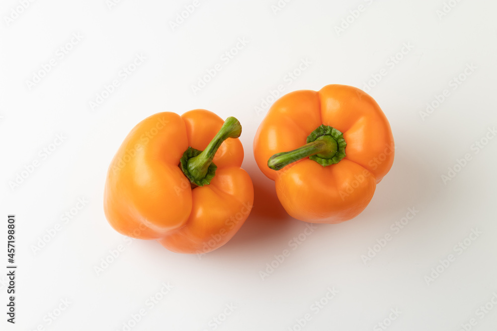 Two orange bell peppers isolated on white background, top view Two orange bell peppers isolated on white background, top view