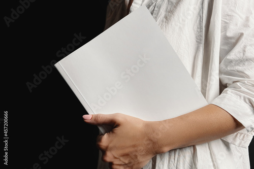 Woman holding softcover book mockup
