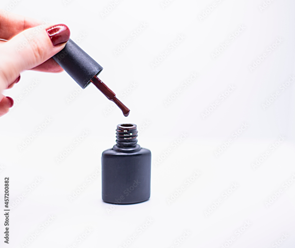 Naklejka premium black bottle of gel nail polish with brush isolated on white background, advertising nail polishes
