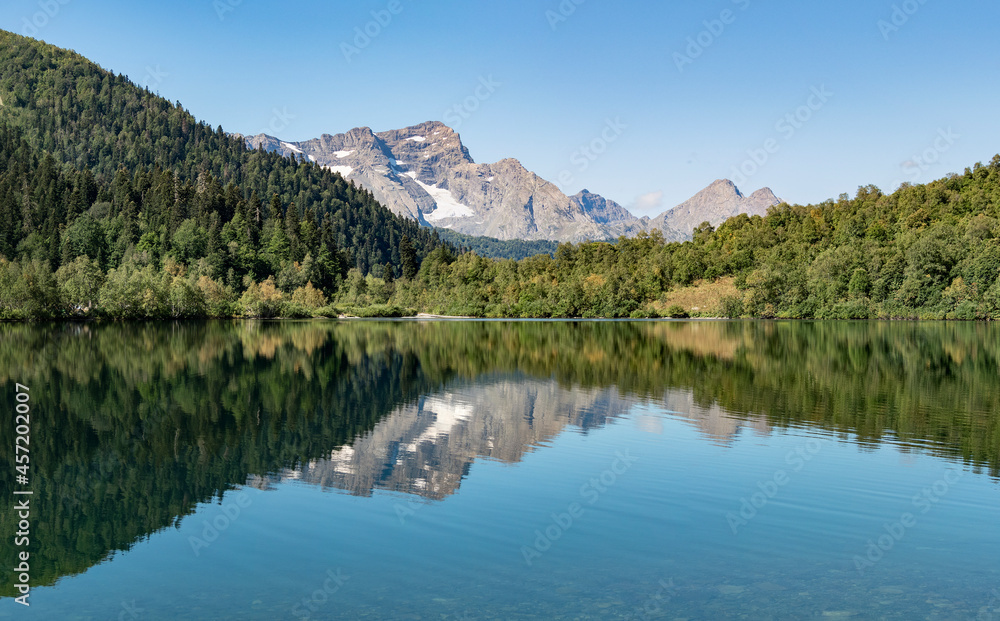 Panoramic view of Kardyvach lake with Agepsta mountain reflection on water surface. Travel destination in Caucasus, Russia Panoramic view of Kardyvach lake with Agepsta mountain reflection on water surface. Travel destination in Caucasus, Russia