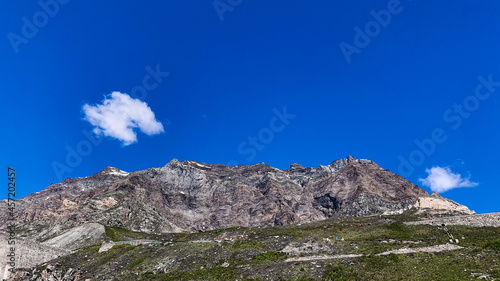 Mountain of Gran Paradiso against a blue cloudy sky on a sunny day