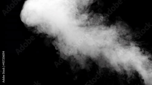 A jet of smoke in slow motion on dark background. Realistic atmospheric gray smoke. Abstract haze cloud. Mist effect and smoke stream effect in 4K.