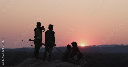 Group of Hadza hunter-gatherer tribesmen out hunting at sunset Tanzania photo