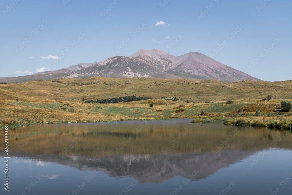 Naklejka premium Beautiful landscape. Yellow hills mountains and small lake and river under blue sky. 