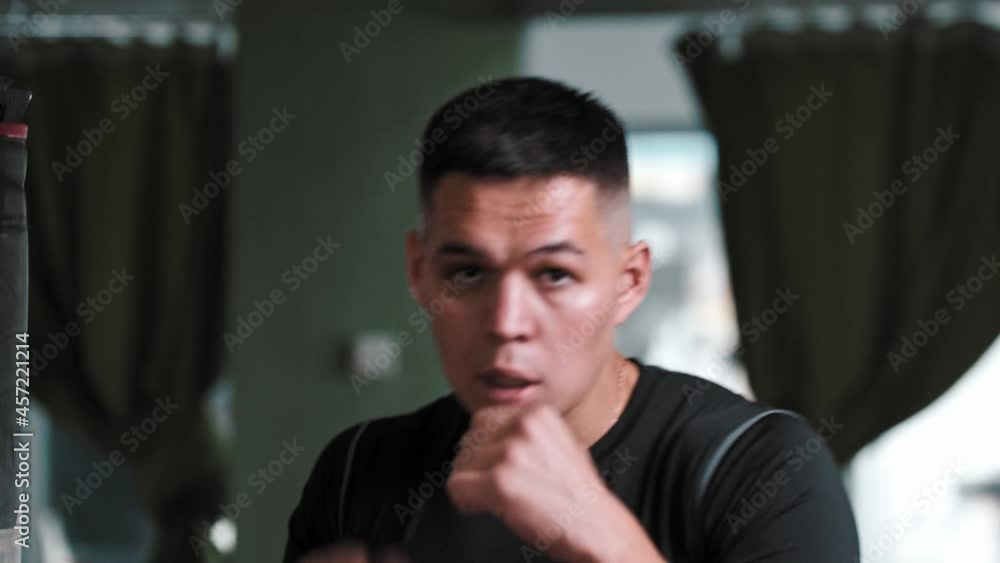 Young man in sportive t-shirt shadow boxing in front of a camera Young man in sportive t-shirt shadow boxing in front of a camera